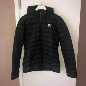  - Vind/vattenavvisande jacka från adidas med luva och dragkedjaförsedda fickor. Figurnära passform med adidas logan på vänster bröst.  Jackan är i god skick då den har använts ett par gånger, orginalpris på jackan ligger mellan 900-1000 kronor.  