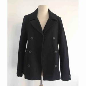  - Dubbelknäppt peacoat i ullblandning.  Märke: H&M   Storlek: 164 (barnstorlek), men passar lätt en XS.   Skick:  Mycket gott. Använd endast ett fåtal gånger.   Pris: 200 kronor eller bud.   Frakt: Betalas av köparen.