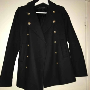  - En supersnygg kappa från Zara i svart med guld knappar. Sparsamt använd och är fortfarande i fint skick.