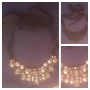  - Söt skimrande stelt sten/strass krage halsband med band från H&M. Använd i bra skick. Påklistrade/påsydda stenar på tyg. Mått: 16x7 cm Banden är ca 50 cm långa. Säljs för 20 kr plus frakt alt avhämtning i Södertälje centrum. Swish. 10% av det jag säljer ger jag till välgörenhet genom targetaid.com, skickar screenshot med donationen 😊