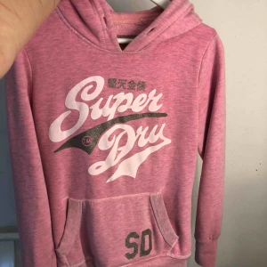  - äkta hoodie ifrån superdry, köpt för ca 2 år sen. Nypris runt 700-800, i använt skick men fint skick men har tyvärr börjat krackelera lite smått i det vita trycket och snöret i luvan har jag tappat bort. Betalning sker via swish💸 Köparen står för frakt💕