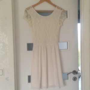  - En jättefin och söt vit klänning perfekt till studenten eller skolavslutning. Använd endast en gång på just skolavslutning. Den är urringad bak och lappen är bortklippt då den syntes för mycket  kan skickas mot fraktkostnaden 

