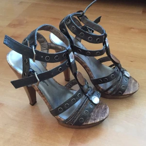  - Sjukt snygga klackskor som jag önskar jag kunde gå i men de är tyvärr för höga för mig. Endast använda 1 gång så ser nya ut. Riktigt fina detaljer samt en snygg brun/trä färg. Hör gärna av er om ni undrar något! 