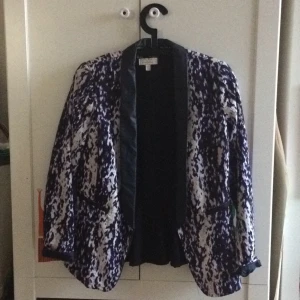  - Super snygg kavaj i snyggt mönster och med skinn detaljer. Använd vid något tillfälle, säljes då jag har en till likadan i en storlek större. Superfint skick! Frakt tillkommer, eller upphämtning i Upplands-Bro :) 