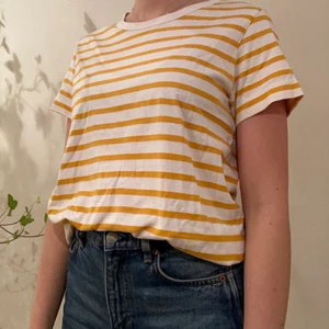 Weekday t-shirt strl: M - Gul- och vitrandig t-shirt från Weekday. Har använts  ett fåtal gånger :) 100% bomull