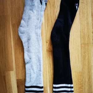 Adidas originals knästrumpor - Hej! Två par knästrumpor i Adidas. Storlek 37-40. Gråa ej använda. Svarta använda ett fåtal gånger.