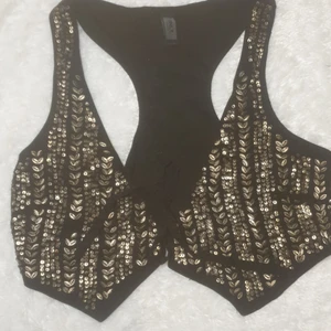Söt svart väst med guld detaljer  - Sparsamt använd. Super snygg över ett svart linne