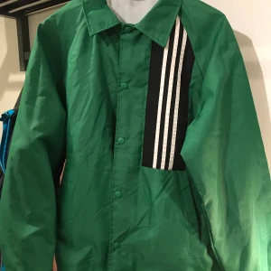 Retro regn/ vindjacka  - Köpt på Beyond Retro. Aldrig använd. Stl M oversize  så den är stor i storleken! Kan knytas åt längst ner. 