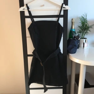 Svart jeansklänning - Superfin oanvänd svart tight jeansklänning med prislapp kvar. Storlek XS, den ena hylsan till skärpet är lite slitet som man kan se till vänster på bild 3. Frakt tillkommer🥰