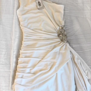 Klänning  - Vit fest klänning. Är en L men passar XS-S-M-L men den sitter ganska löst på mig som är en XS. Aldrig använd med prislapp på. 