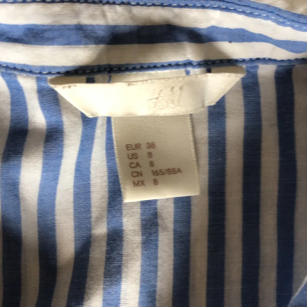 Armlös vit/blå randig skjorta från H&M stl 38. Lite längre modell. . Skjortor.