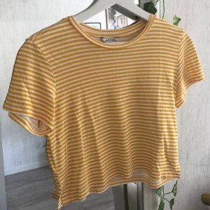 Croppad t-shirt - Söt croppad t-shirt från Monki, gul och vitrandig med små slitsar längst ner ✨💛 70 kr inkl frakt! 
