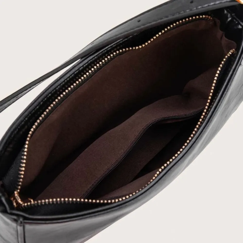En fin svart shoulderbag i läder imitation med reglerbara band så att den kan passa alla. Helt ny! Frakt tillkommer på priset. Väskor.