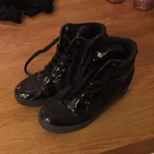  - Fina sneakers med hög sula i svart med glitter. Bra begagnat skick. Storlek 38 men upplever dem som något små. Köparen står för eventuell frakt.