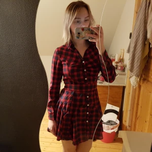  - En blå-röd rutig skjort klänning, som är "flowy" nertill men tight upptill (väldigt liten vid brösten). Finns ett tillkommande band man kan ha runt midjan om man skulle vilja. Köparen står för frakten. OBS, katt i hemmet. 