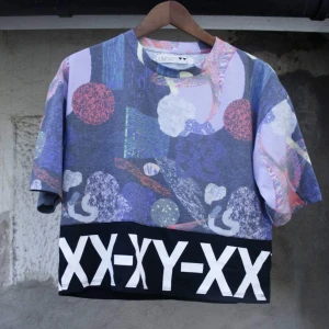  - Oversize t-shirt från Junkyard XX-XY. Lite kortare och större modell för att vara en S. (Jag är stl M) Snygg till hög kjol eller höga byxor. Snyggt mönstrat typ upptill och svart tyg runt hela. Bra begagnat skick. Frakt 36kr 