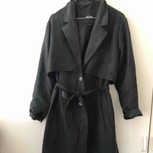  - Trenchcoat från Monki. Storlek M men mycket generös i storlek passar även L och XL.   Är själv 1,59 cm för uppfattning om jackans längd. 