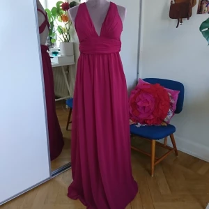  - Från NELLY, Vindröd, Chiffong tyg, Storklek 34 (vadderad så man behöver ingen BH) korsad i ryggen  (prov dockan är lite för stor så klänningen går inte att stänga men det är inget problem med dragkedjan!)  Frakt 27kr. Betalning via swish 