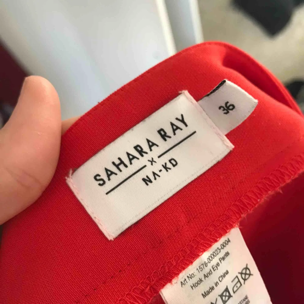 Snygga byxor från Sahara Ray’s kollektion för NAKD. Röda med hakor på sidorna som man kan dra upp om man vill ha slitsar i byxorna. De är röda & i perfekt skick. . Jeans & Byxor.