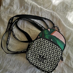 Adidas ryggsäck/ väska  - Jättefin addidas väska som går att använda som liten ryggsäck men också som axelväska. Ingå två axelband som går att sätta hur man vill. Mått - Höjd: 23, bredd: 16, djup: 10 cm och axelband: 77 cm som minsta sträcka kan dras ut väldigt mkt. Ny pris 499:- Finns på andra sidor annars 180:-  ink frakt (vanligt brev) med spårbart blir det lite dyrare. Hör gärna av er om ni vill ha fler bilder. 