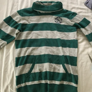 Randig polotröja med ficka - Väldigt fin polotröja med lång polokrage så att man får vika den 2-3 ggr för att få den som på bilderna. Har mudd vid handlederna och midjan. Har använt ett fåtal gånger. På bröstet har den ett svart märke (bild 3). Tar bara swish 🤗