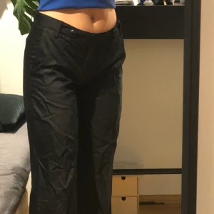 Lågmidjade svarta kostymbyxor stl 38 - As balla lågmidjade svarta kostym byxor med raka ben. Kommer tyvärr inte till användning så känns bättre att sälja vidare. Perfekta i längden på mig som är 1,69. Nypris ligger runt 900kr. Köparen betalar frakten💫☘️
