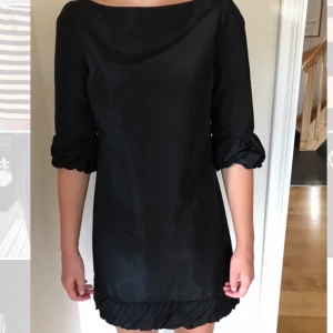Svart festklänning - Säljer denna svarta festklänningen från Zara i blankt tyg, kostar 70kr plus 44kr frakt. 