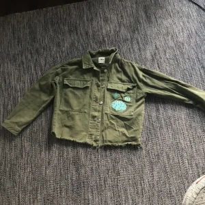 Zara Jeansjacka cropped militärgrön XS - En grön Jeansjacka från Zara nästan aldrig använd. Strykt på tre små detaljer på en fickan. Inköpt för 399 kr priset kan diskuteras!