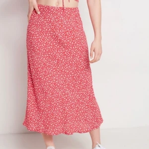 Rödblommig kjol - Strl XL, men passar de flesta då det är resårband i midjan. Aldrig använd. Frakt ingår i priset 