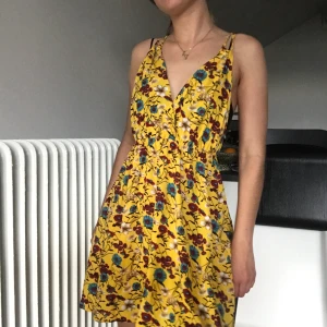 Blommig klänning  - Gul söt sommarklänning med blommor. 