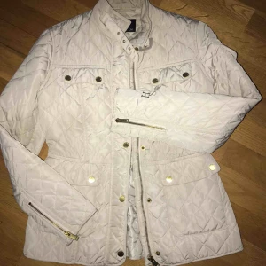 - Figursydd beige jacka. 