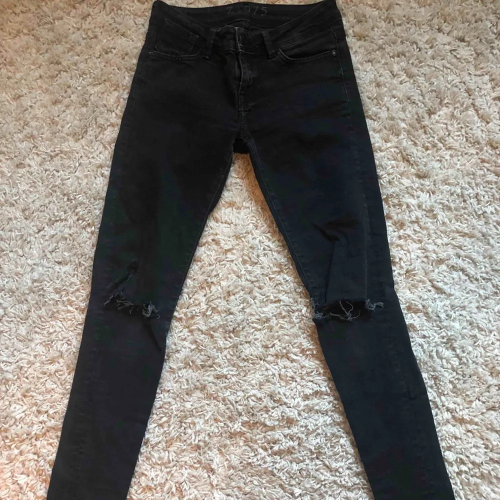 Svarta jeans med egen klippta hål vid knäna. . Jeans & Byxor.