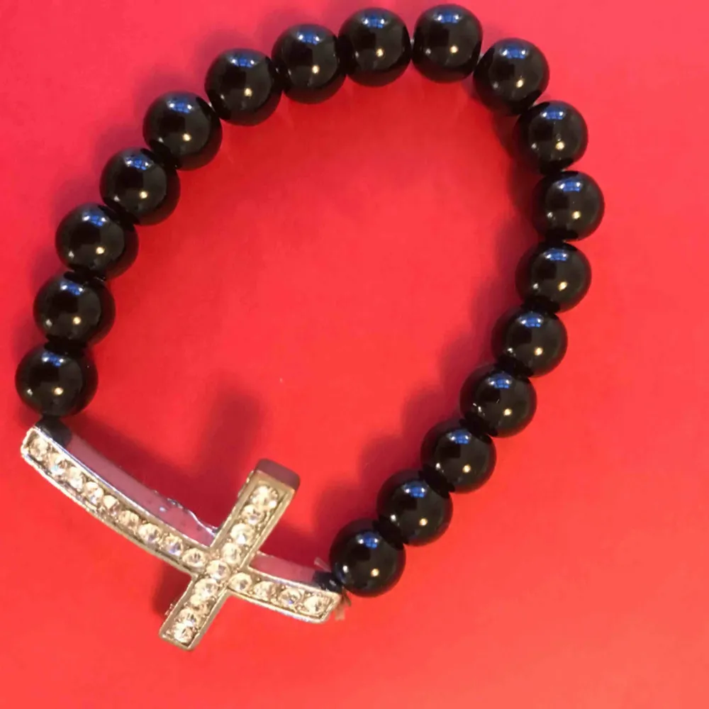 Armband med svarta pärlor och en kors , priset inkl frakten . Accessoarer.