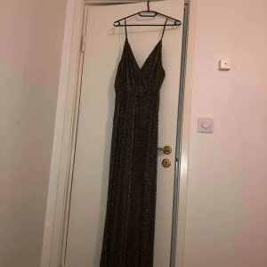  - Guldig/svart byxdress från bikbok med justerbara band. storlek M