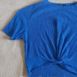 Cropped blå tröja i crepematerial med  knutdetalj Köparen betalar frakten