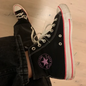 Limiterade Converse med rosa detaljer  - Svarta limiterade converse med rosa och lila detaljer köpta i USA för tre år sedan men har endast använt dom ett fåtal gånger, därmed nästan som nya, storlek 37,5 men skulle säga att dom passar 38! As balla skor, buda på!