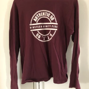 Långärmad röd tröja  - Långärmad röd tröja från Gina Tricot i storlek s. Passar större storlekar. Ett vitt tryck på. Färgen är mörkröd. Köparen står för frakten.