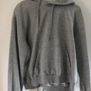 Grå hoodie - En grå simpel hoodie från h&m. Använd fåtal gånger. Inte jätte tjockt material. Storlek L men inte jätte stor i storleken. Köparen står för frakten.