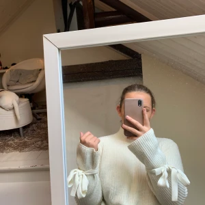 Vit stickad tröja - Stickad tröja med knyten i armarna på båda sidor. 