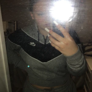 Nike ”croppad” hoodie - En croppad hoodie från Nike med liten dragkedja där fram. Använd fåtal gånger. Storlek M. Nypris runt 700.