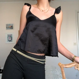 Svart Partytop  - Supersnygg svart top i silkesimitation. Sitter supersnyggt och enkel att klä upp och ner. Låg rygg och justerbara axelband 🔮