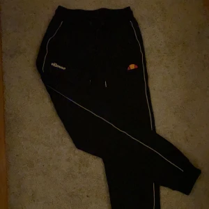 Ellesse byxor - Snygga och sköna svart Ellesse mjukisbyxor (lite mer åt tränings material hållet) med två reflexränder på varje ben som tyvärr blivit för korta för mig. Använda men väldigt fint skick, inte urtvättade då materialet inte blir de, inga hål eller andra ”skador” 150+ frakt🥰