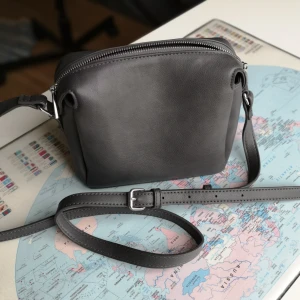 Snygg handväska - Skitsnygg handväska i skinnimitation från Åhléns. I princip ny. Jättefin kvalitet och snygg grå färg. Skicka pm om du vill ha mått. Justerbart axelband. 