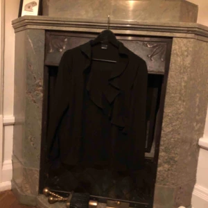  - Söt blus från Gina tricot, storlek 38. Svart med volanger kring v-ring samt i slutet på ärmarna. Jättefint skick! 