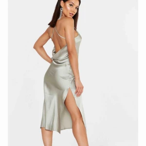  - Aldrig använd superfin satin klänning i färgen dusty green. Den har en slits vid ena benet och en öppen rygg. Säljs då jag beställde den i fel strl  Köparen står för frakt :) 