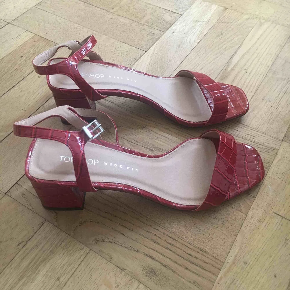 Helt nya aldrig använda sandaletter i charmig röd färg och fake ormläder. Super tjusiga! :) Frakt ligger på 75 kr. Skor.