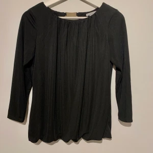 Svart blus/ oanvänd/ storlek S/M - Svart blus från H&M - aldrig använd! Blusen har ett guldknäppe på baksidan och är veckad med resor längst ned. Storlek medium, men passar även small. Säljes då denna är för liten för mig. 