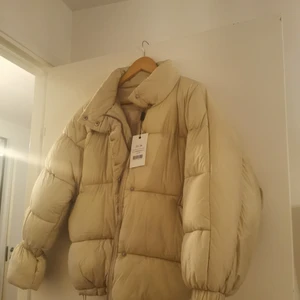 NAKD puffer jacket strl 36 - Oanvänd. Lappen sitter kvar. Beige. Storlek 36.