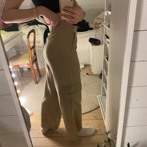 Beiga kostymbyxor - kostymbyxor med lite ”cargo” stil. Sitter bra i midjan och är vida nedtill. Köpta från ginatricot, endast använda fåtal gånger. Strl 36. Köparen står för frakt 🤎