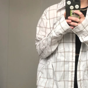 Rutig vit och beige skjorta - Vit och beige skjorta i bra oversized model på mig som är M normalt. Materialet är åt det tunnare hållet och är därför väldigt skönt när det är lite varmare. Köparen står för frakt. 